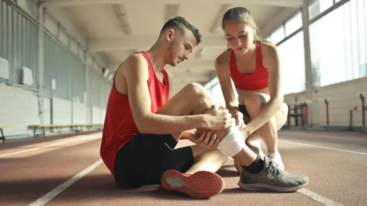 Woman Wrapping Man's Leg with Bandage