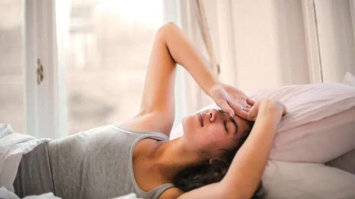 Woman in Gray Tank Top Lying on Bed